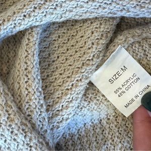 Beige sweater with buttons.